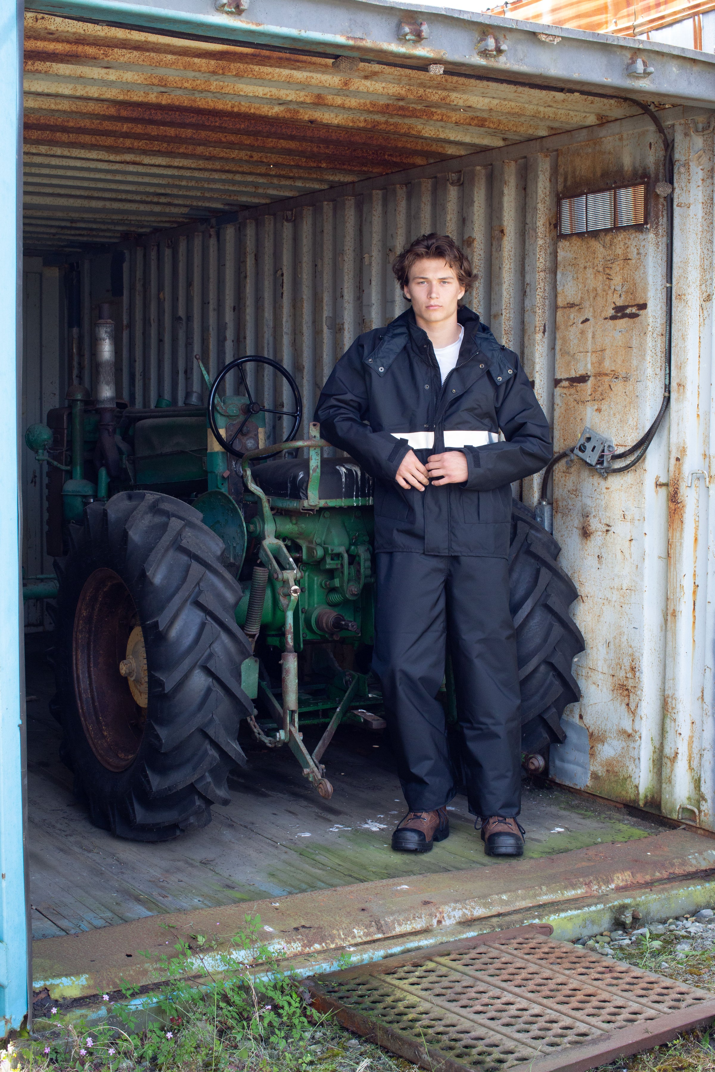 A worker in the Apex Unlined Rain Jacket on a clear day